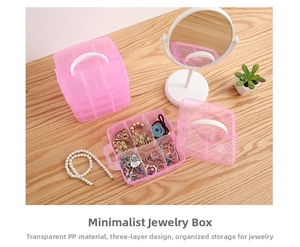 Detailed view of pink 3-tier clear plastic jewelry box with dividers on wooden desk