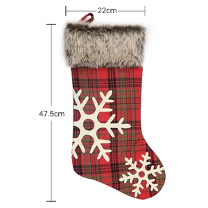 Classic red and green plaid Christmas stocking with fur cuff and white snowflake patterns