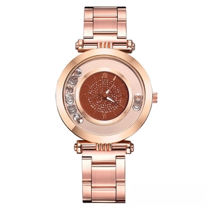 Détail du cadran de montre or rose avec cristaux mobiles et chiffres romains élégants