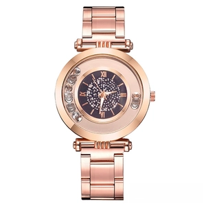 Gros plan du cadran de montre or rose avec strass mobiles et chiffres romains