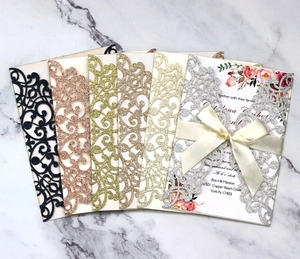 Macro detail of laser-cut glitter wedding invitations in multiple metallic colors