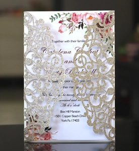 Detail of laser cut hollow invitation card with gold glitter paper and elegant engraving