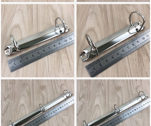 Macro shot showing silver metal binder clips in different lengths on a wood surface