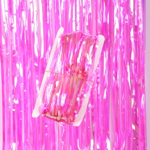 Detail of pink laser tinsel curtain roll on white spool for party backdrop decoration