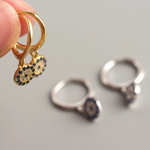 Macro shot of S925 silver evil eye hoop earrings in gold and silver finishes