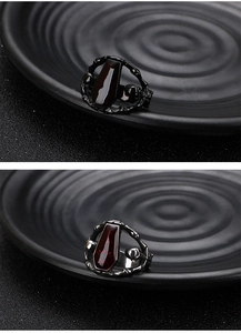 Close-up of gothic punk coffin ring with deep red inlay and bone-textured steel band