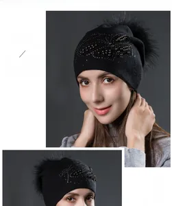 Détail du bonnet en tricot noir avec pompon en fourrure et motifs de perles argent