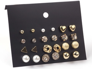 Detail shot of 12 pairs of gold geometric earrings with pearls and crystals on black card