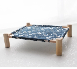 Detail of wooden pet hammock with dark blue cat print fabric in a minimalist setting