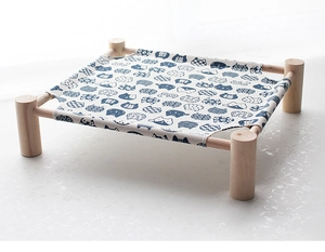Detail of wooden pet hammock featuring blue canvas with cat patterns and sturdy timber frame