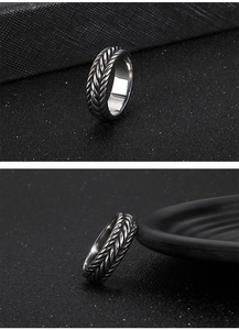 Macro detail of industrial punk style stainless steel ring with braided wheat pattern texture