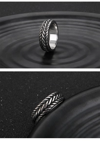 Detailed view of silver braided wheat pattern and polished interior of a punk steel ring
