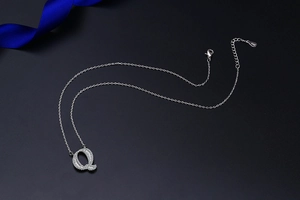 Macro view of S925 sterling silver letter Q pendant with shimmering pave zircon stones