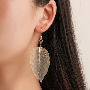 Vintage long hollow leaf earrings in gold finish worn by model for elegant style