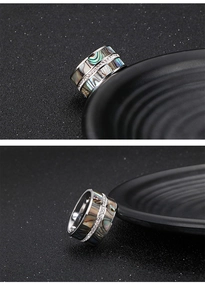 Macro shot of silver titanium ring with iridescent abalone shell and pavé rhinestones
