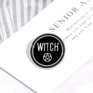Macro shot of circular enamel Witch pin with pentagram on black background