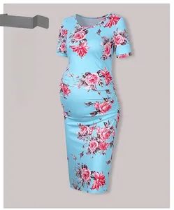 Close-up of ruched side detailing and pink rose floral print on blue maternity dress
