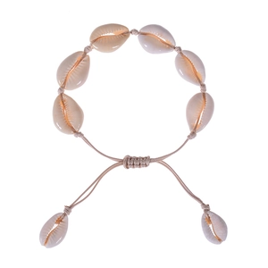 Detail of handmade bohemian shell bracelet with beige woven cord and adjustable knot