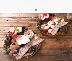 Detail of Christmas rattan wreaths featuring Santa Claus and snowman on a wooden surface