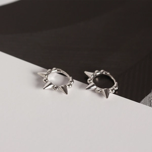 Close-up of S925 sterling silver hoop earrings with punk spikes and metallic beads