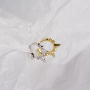 Close-up of gold and silver S925 sterling silver hoop earrings with punk spike details