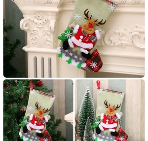 Detailed reindeer style linen Christmas stocking with red plaid trim and holiday decorations
