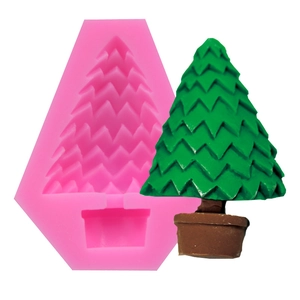Detail view of pink silicone mold with green Christmas tree craft on white background