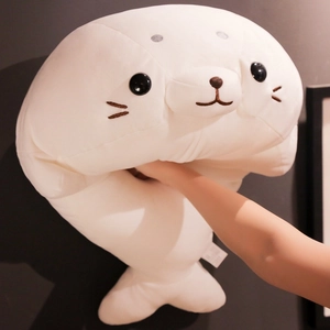 Squishy white seal plush pillow being squeezed to show its soft elastic texture