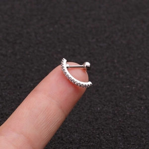 Macro detail of curved silver surgical steel stud earring with sparkling cubic zirconia