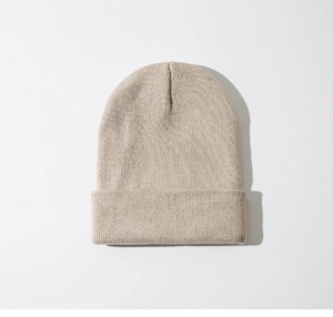 Detailopname van de beige gebreide muts met fijne textuur en warme gebreide steken