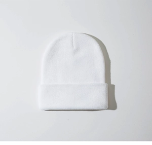 Detailopname van de puur witte gebreide muts met fijne verticale ribstructuur en stof