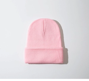 Detailopname van de roze gebreide muts met zachte textuur en fijn gebreid patroon
