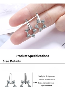 Macro detail of star-shaped silver drop earrings with zircons measuring 22mm in length