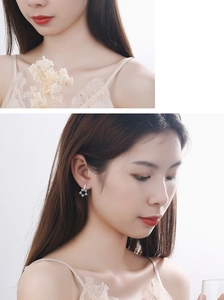 Detail view of silver star earrings with micro-inlaid rhinestones on a female model