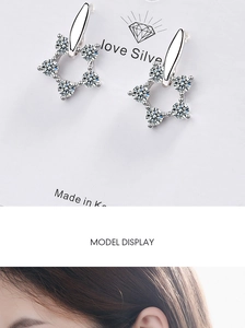 Detail view of silver sparkling zircon stud earrings with a model wearing showcase