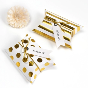 Mini white pillow boxes with gold foil stripes and dots, featuring handmade gift tags
