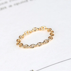 Macro shot of interlocking gold chain links on a minimalist s925 silver leaf choker