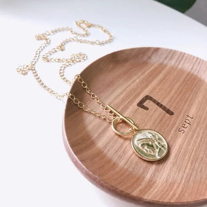 Macro view of gold coin pendant necklace with portrait relief and stylish toggle clasp