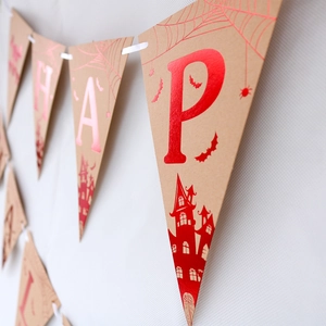 Detail of Halloween banner showing Kraft paper flags with gold foiled spider and bats