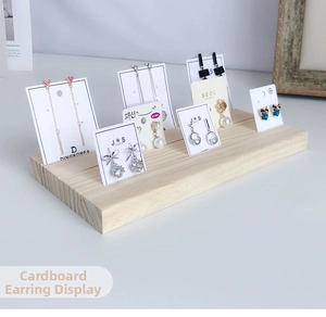 Close-up of wooden earring display stand with three parallel slots for jewelry cards