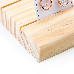 Solid wood earring display stand with slots for jewelry cards and natural pine texture