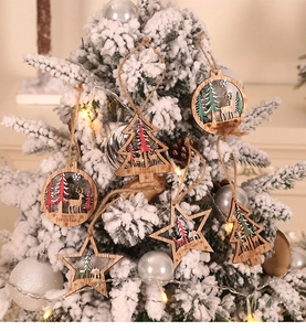Detail of laser-cut wooden Christmas ornaments with reindeer motifs on a snowy tree