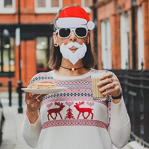 Close-up of a Santa Claus mask and Christmas reindeer knit sweater on a model