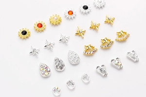 Détails de bijoux d'ongles en alliage avec strass colorés et perles sur fond blanc pur