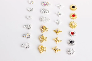 Vue macro de bijoux d'ongles variés avec perles, strass et formes en alliage métallique