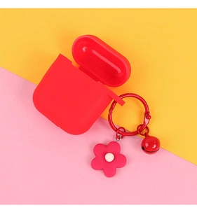Detail of red silicone earphone case with flower charm and bell on vibrant background