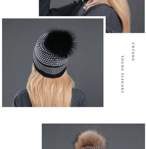 Rear view of knit beanie with plush raccoon fur pompom and tricolor geometric pattern