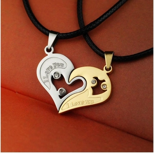 Detailed close-up of interlocking gold and silver heart pendants with I Love You engraving