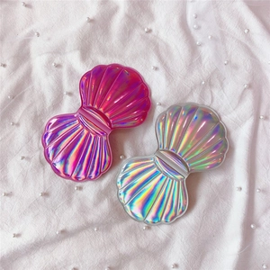 Detail of shell-shaped makeup mirrors with a holographic laser finish and pearl decor