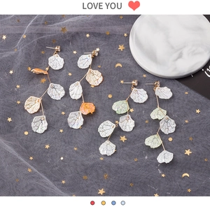 Détail des boucles d'oreilles pétales de nacre multicouches avec perles et chaînes